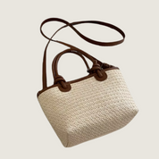 Bolsa Carafori casual chic em palha bege com alças marrons, estilo atemporal e funcional.