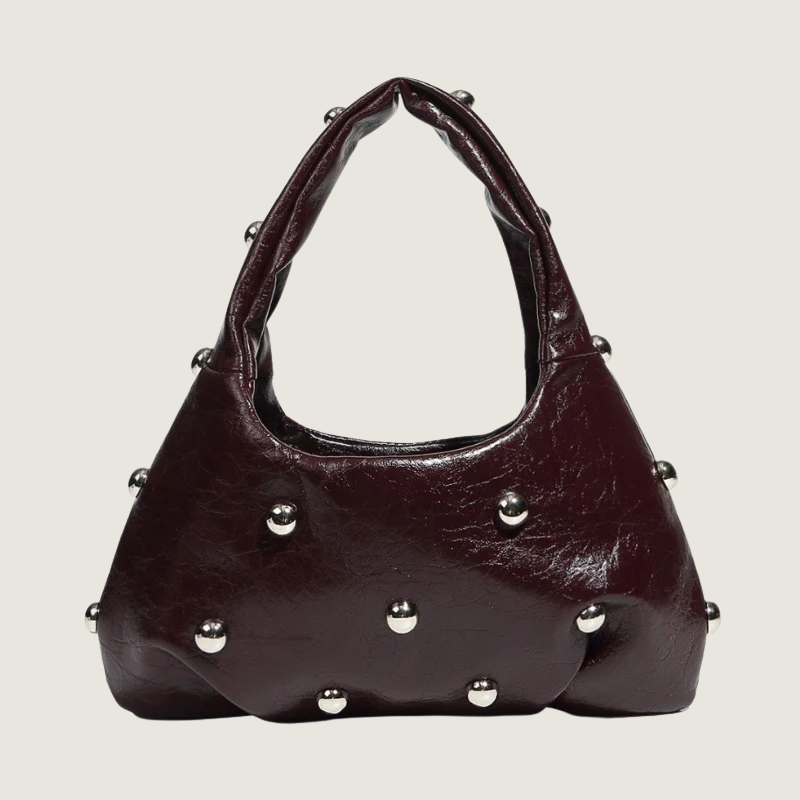 Bolsa feminina Carafori em couro macio com design exclusivo e detalhes em rebites prateados sofisticados.