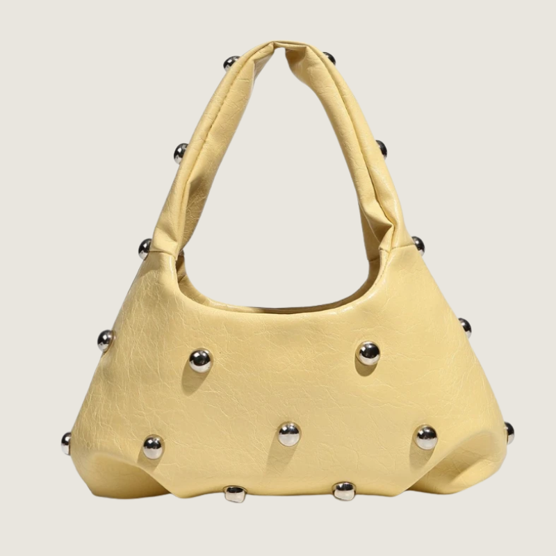 Bolsa feminina Carafori inspirada na moda urbana, com rebites metálicos e acabamento refinado.