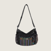 Bolsa boho feminina em denim com bordado étnico colorido, versátil para uso no ombro ou transversal.